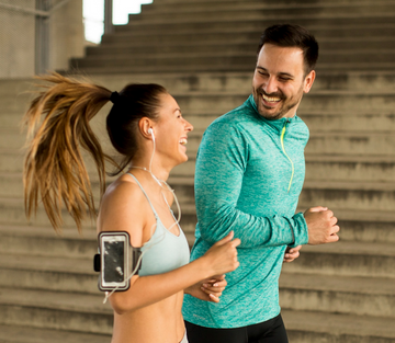 Two runners taking a break on stairs, smiling and laughing, feeling better after a gummy routine